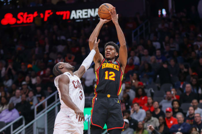 Mar 28, 2023; Atlanta, Georgia, USA; Atlanta Hawks forward De'Andre Hunter (12) shoots over Cleveland Cavaliers guard Caris LeVert (3) in the second half at State Farm Arena. Mandatory Credit: Brett Davis-USA TODAY Sports